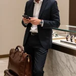 Individual admiring a collection of clone watches in a luxury boutique, showcasing craftsmanship and elegance.